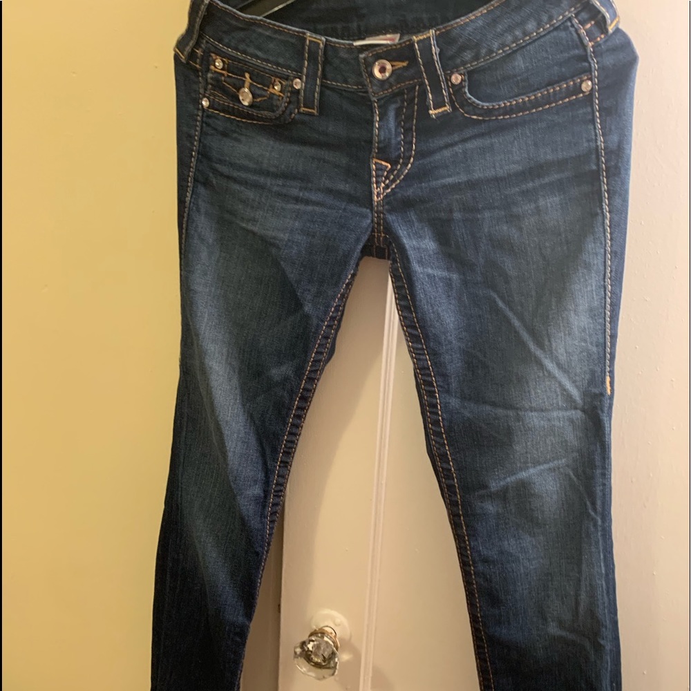 Medium wash  skinny jeans with crystal buttons .